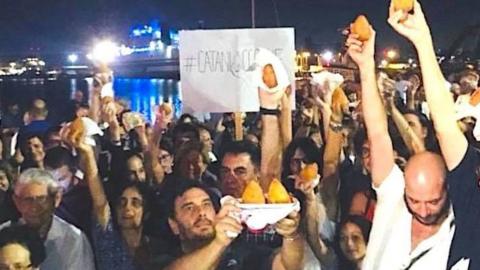 Protestors brandishing arancini in Catania, Sicily, where a boat with around 200 rescued migrants who have been denied permission to disembark