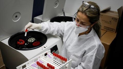 A health worker takes test tubes with plasma and blood samples from a centrifuge after a separation process during a coronavirus disease (COVID-19) vaccination study at the Research Centers of America, in Hollywood, Florida, U.S., September 24, 2020