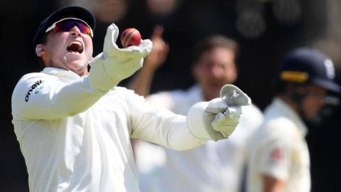 Gary Wilson celebrates taking the catch to dismiss England batsman Rory Burns at Lords last year