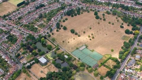 The grass on playing fields near Arnos Grove, North East London, is seen scorched and yellow