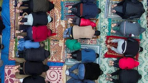 People praying outside of al-Farouk mosque ruins in Rafah on 10 April