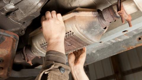 A catalytic converter being removed from an SUV car
