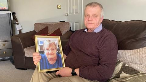 Thomas Duncan, pictured with a framed photo of his wife Janet