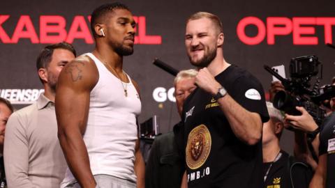 Anthony Joshua with his hands in his pockets stares at Otto Wallin