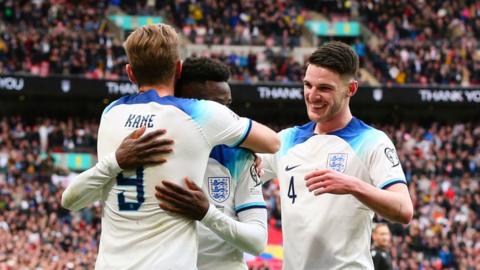 Bukayo Saka celebrates with Harry Kane and Declan Rice