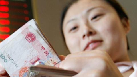 Woman counts Chinese yuan bills