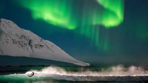 Surfing beneath the Northern Lights