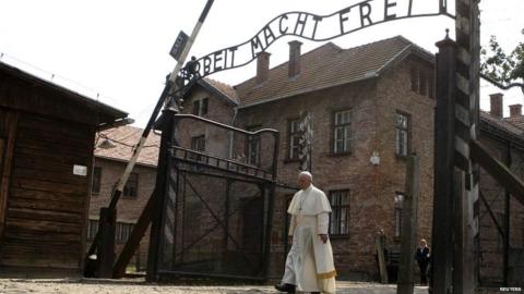 Pope Francis walks through the Auschwitz camp gates