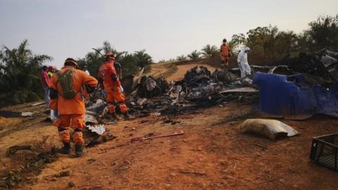 picture released by Colombia"s Civil Defense press service showing members of civil defense at the site of a plane DC-3 crash in San Martin