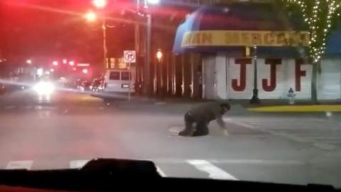 Man exiting manhole on to street