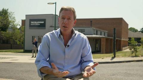 Frank Gardner gesturing outside a building