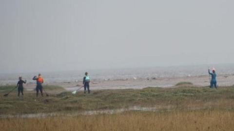 People on the saltmarsh at Cleethorpes