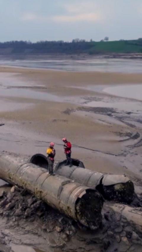 Drone shot of two men on a old piece of bridge.