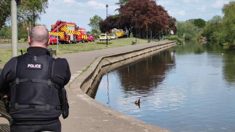 Emergency service vehicles alongside River Nene