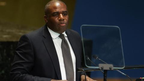 David Lammy sits in a black blazer and white shirt at the Summit of the Future in the General Assembly Hall of the United Nations Headquarters in New York City