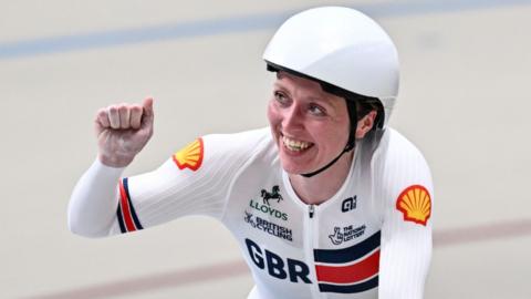 Anna Morris smiles and raises a fist in triumph