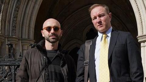 Carlo Palombo and Tom Hayes stand outside the Royal Courts of Justice