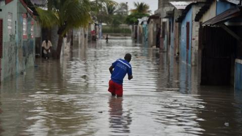 A man walks in a flooded street in Port-au-Prince, Haiti