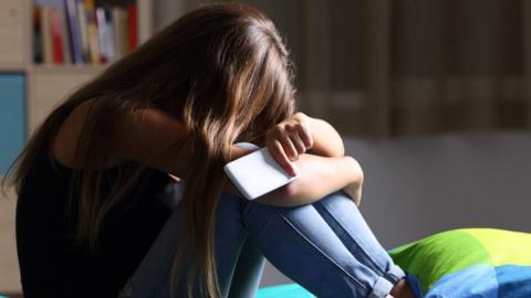 Young woman with phone looking upset