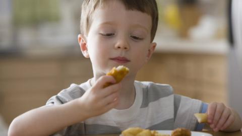 boy eating chicken nuggets -