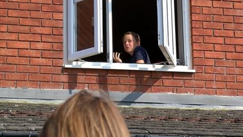 Billy sat in his window speaking to a reporter