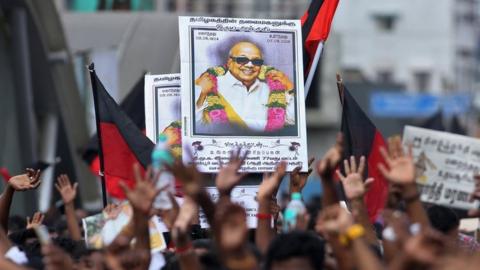 Supporters hold the portrait of M Karunanidhi during his funeral in Chennai on 8 August 2018.