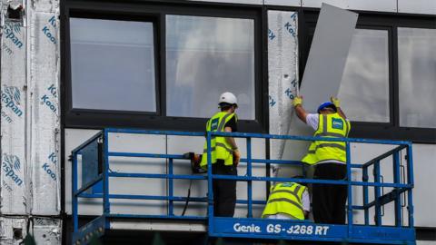 Cladding being removed from a building