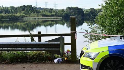 A police car parked next to Enagh Lough, where two boys drowned