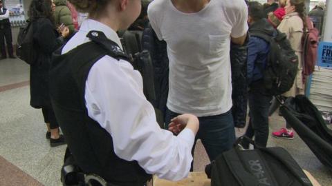 A man being searched by a policewoman