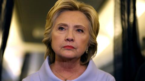 Hillary Clinton stands in her campaign plane.