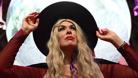 A women dressed as a witch stands in front of the Museum of the Moon by Luke Jerram in the Guildhall Derry as the Halloween Festival comes to a close on October 31, 2025 in Derry/Londonderry