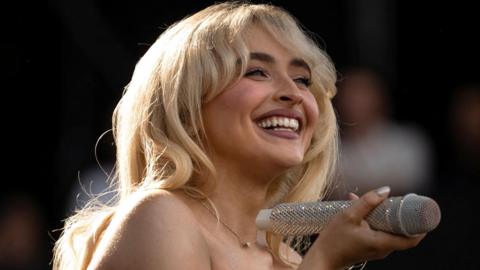 Sabrina Carpenter smiling on stage