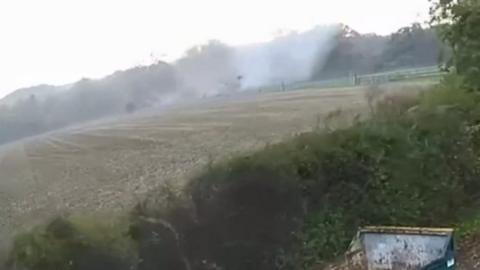 Tornado hits buildings in a field