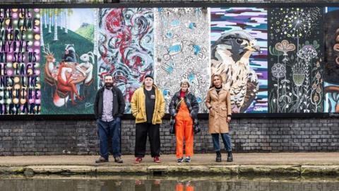 Artists in front of the outdoor art gallery