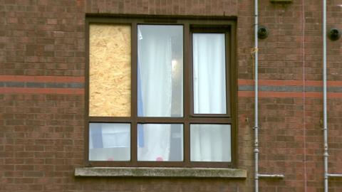A boarded-up window at the flat where the fight to place
