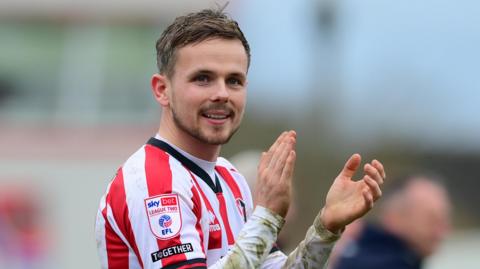 Cheltenham Town's Liam Kinsella applauding.