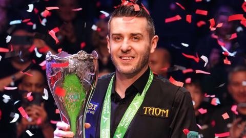 Mark Selby holds trophy while confetti falls