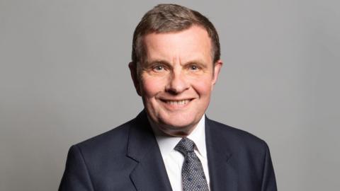 Llun o David Jones mewn siwt.