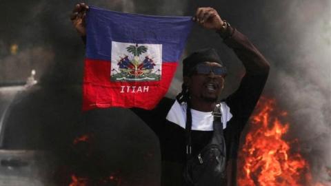A demonstrator holds up a Haitian flag during a protest against Prime Minister Ariel Henry's government and insecurity, in Port-au-Prince, Haiti March 1, 2024.
