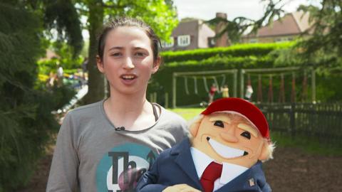 A young girl with a Donald Trump puppet.