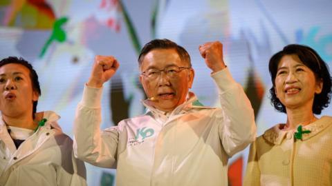 Standing in the centre of a stage, Taiwan People's Party leader and presidential candidate Dr. Ko Wen-jie clinches his fists during a political rally organised by his party.