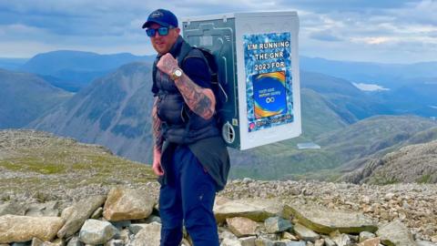 Stephen Sinclair with a tumble dryer on his back on Scafell Pike