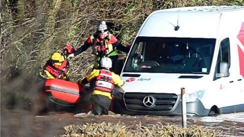 Emergency services rescue a DPD delivery van driver stranded in flood water in Newbridge on Usk