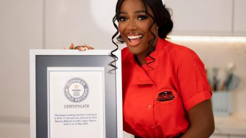 A woman holding up a Guinness World Record plaque