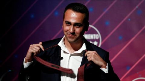 Italy's Foreign Minister Luigi Di Maio takes off his tie during a news conference in Rome, Italy, January 22, 2020
