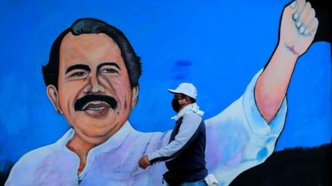 A man walks by a mural depicting Nicaraguan President Daniel Ortega, in Managua