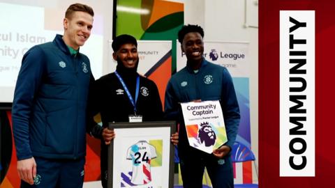 Luton Town FC Community Trust, School’s Officer Hafizul Islam poses with goalkeeper Thomas Kaminski and midfielder Sambi Lokonga