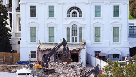 The White House with a wrecker machine out front, on a pile of rubble
