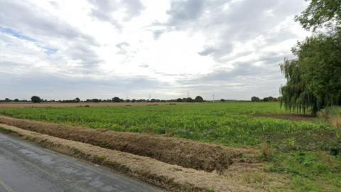 An empty field near the village of Hillam. Only trees can be seen in the distance.