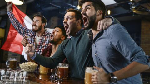 Friends in bar watching game